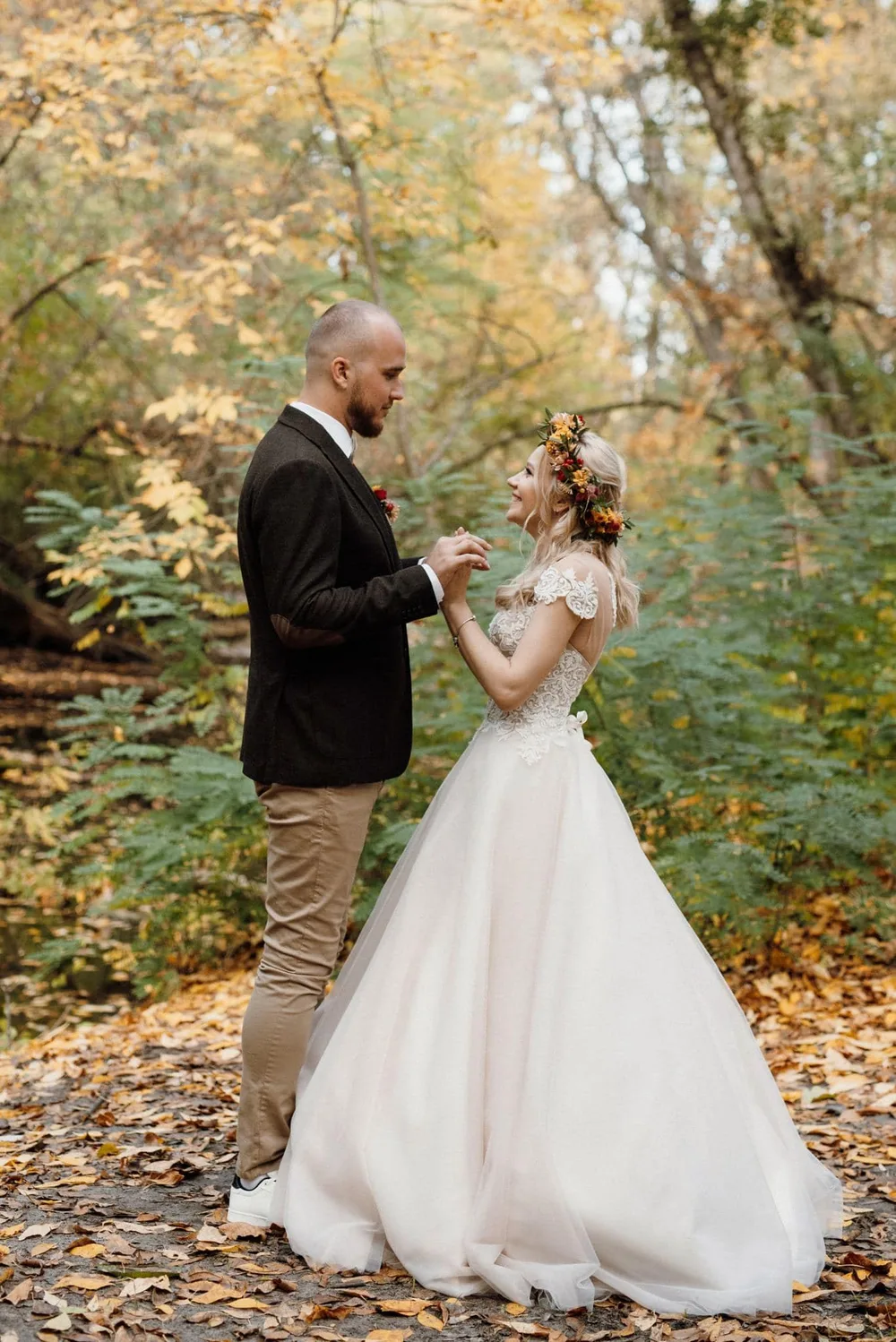 Alliances de mariage 2024 reposant sur du velours vert émeraude et bois précieux