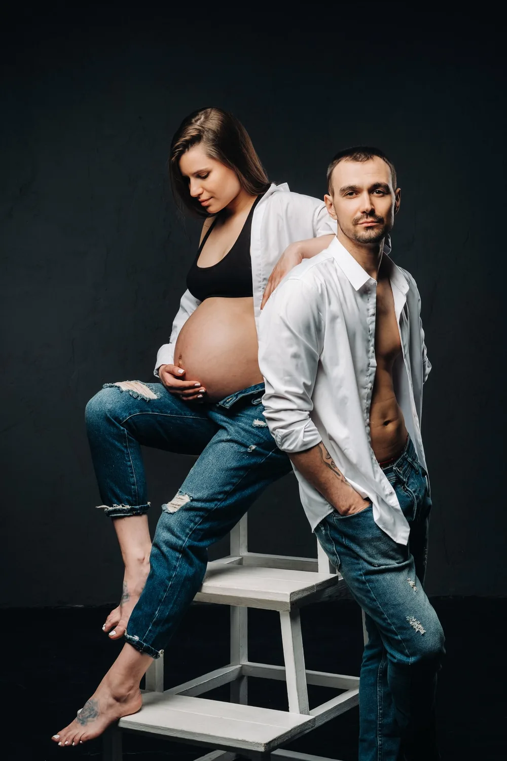 Grand frère posant délicatement sa main sur le ventre rond de sa maman