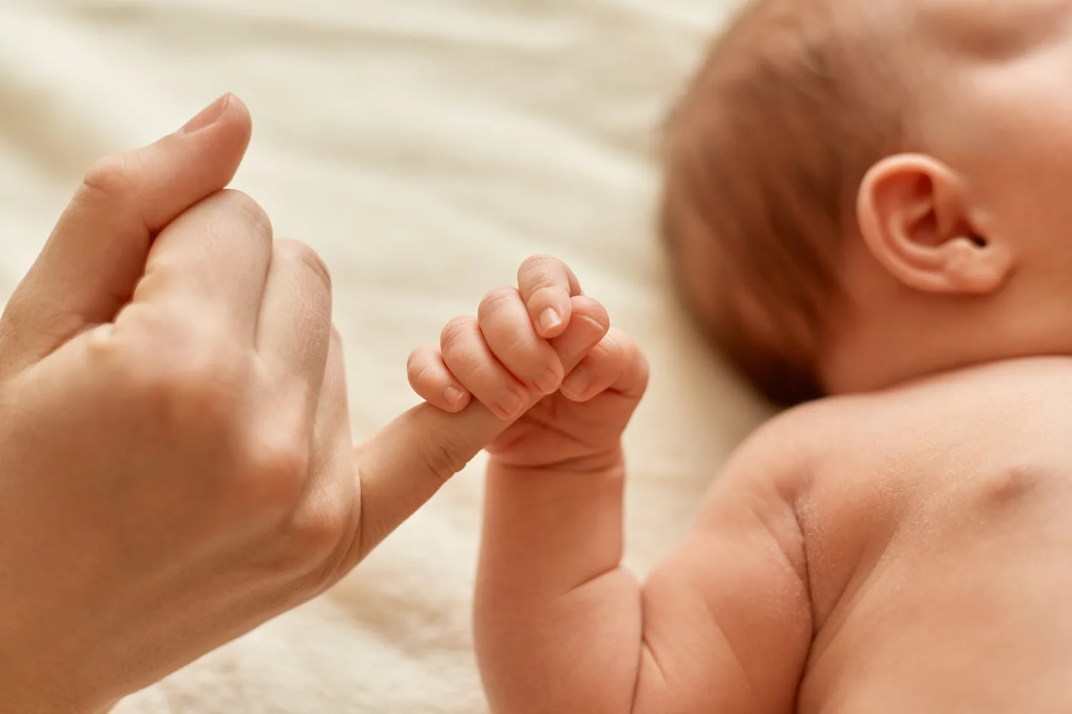Mère berçant tendrement son nouveau-né contre son épaule en lumière douce