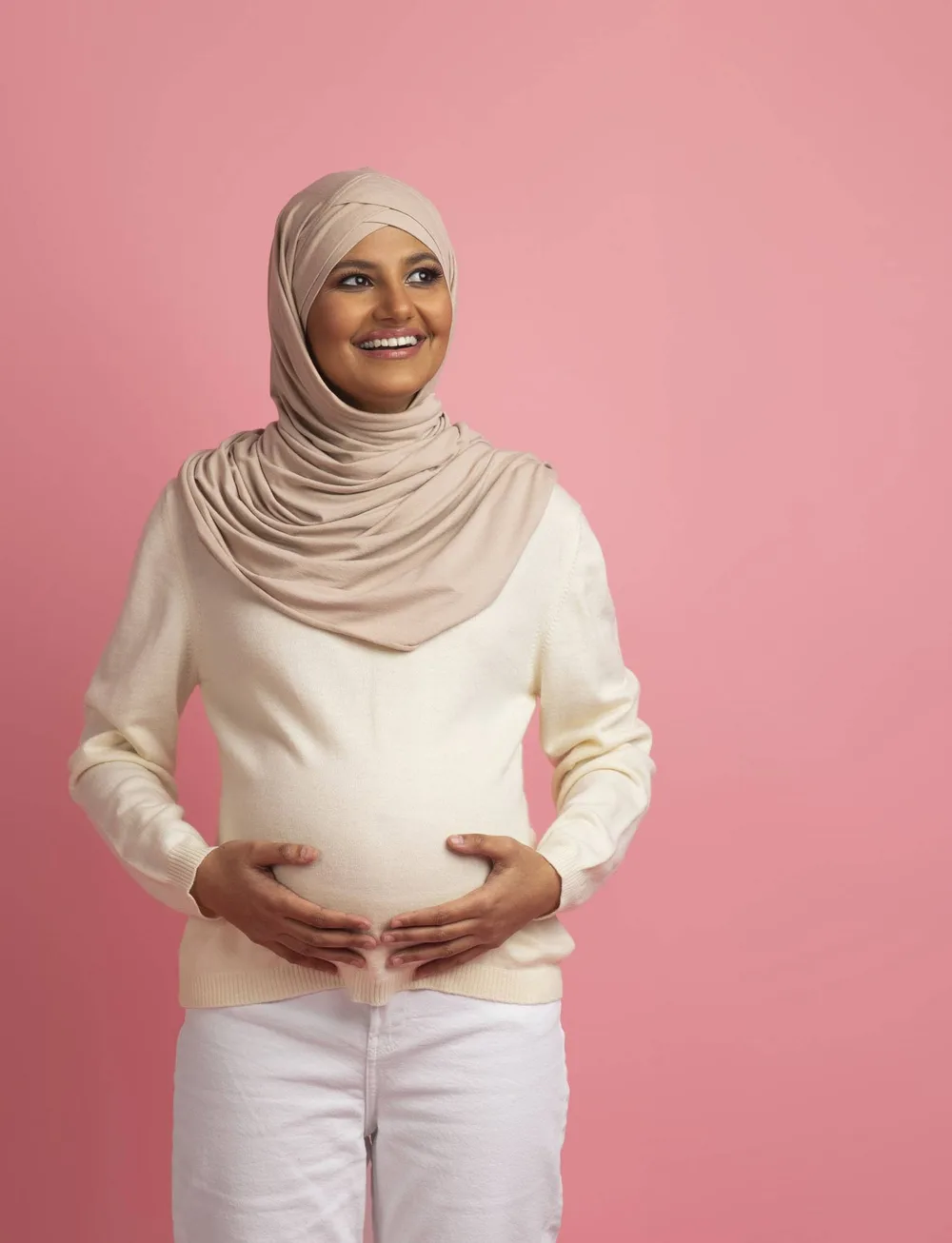 Femme enceinte posant dans un parc au coucher du soleil